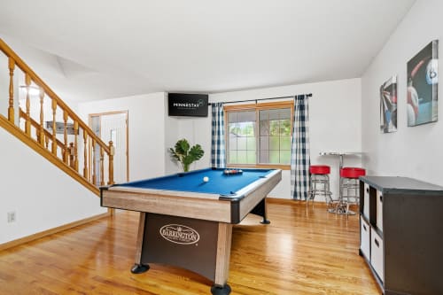 A vibrant game room featuring a billiards table and modern seating.