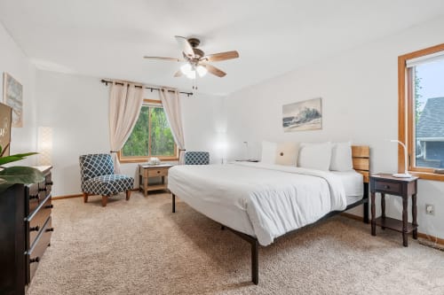 A modern, serene bedroom filled with natural light and stylish furnishings.