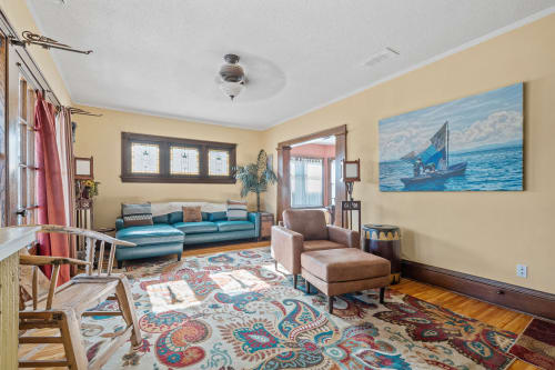 A cozy living room featuring a teal sectional couch and vibrant area rug.