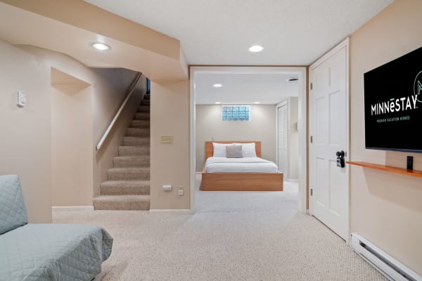 Modern basement suite with a cozy bedroom and TV.