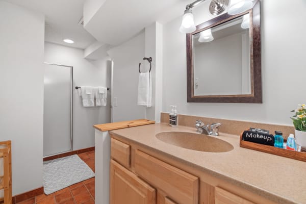 Modern bathroom with a shower, vanity, and decorative flowers.