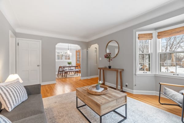Cozy living room with gray walls, bay windows, and stylish furniture.