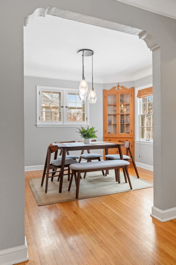 Cozy dining room with wooden table, gray chairs, and pendant lights.