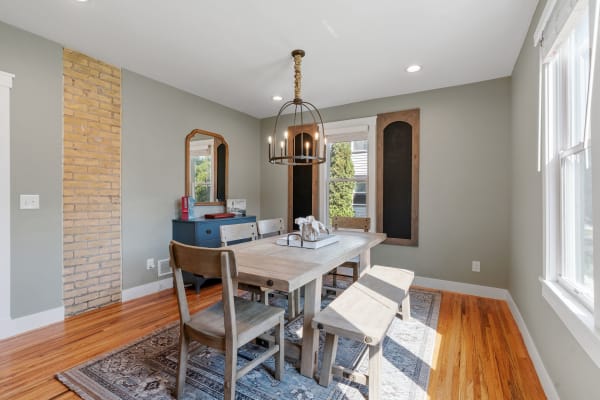 Dining room featuring a wooden table, benches, and a blue dresser with a mirror.