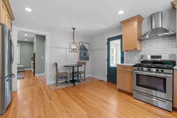 Cozy kitchen with wooden cabinets, stainless steel appliances, and a round dining table.
