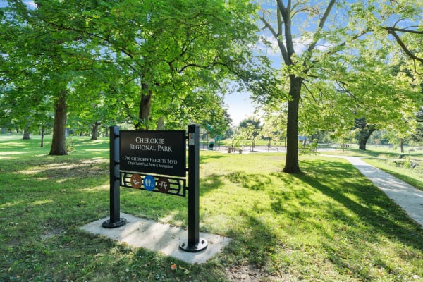 Sign marking Cherokee Regional Park surrounded by lush greenery and pathways.