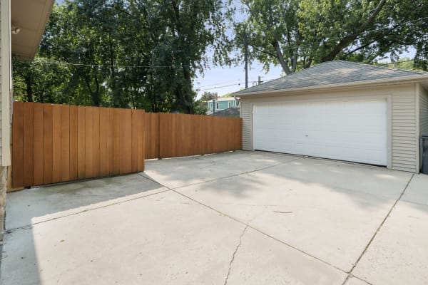 Driveway with a wooden fence and a garage.