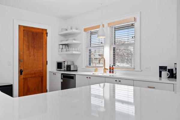 Contemporary kitchen featuring a wooden door, white countertops, and modern appliances.
