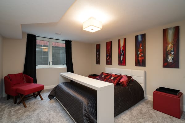 Stylish bedroom with a large bed, colorful wall art, and a cozy accent chair.