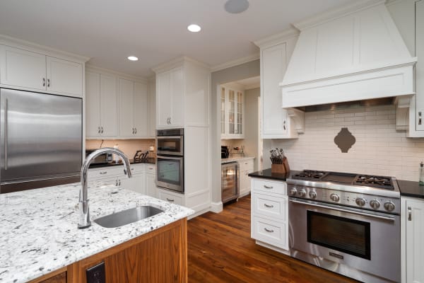Elegant kitchen with white cabinets and a granite island.