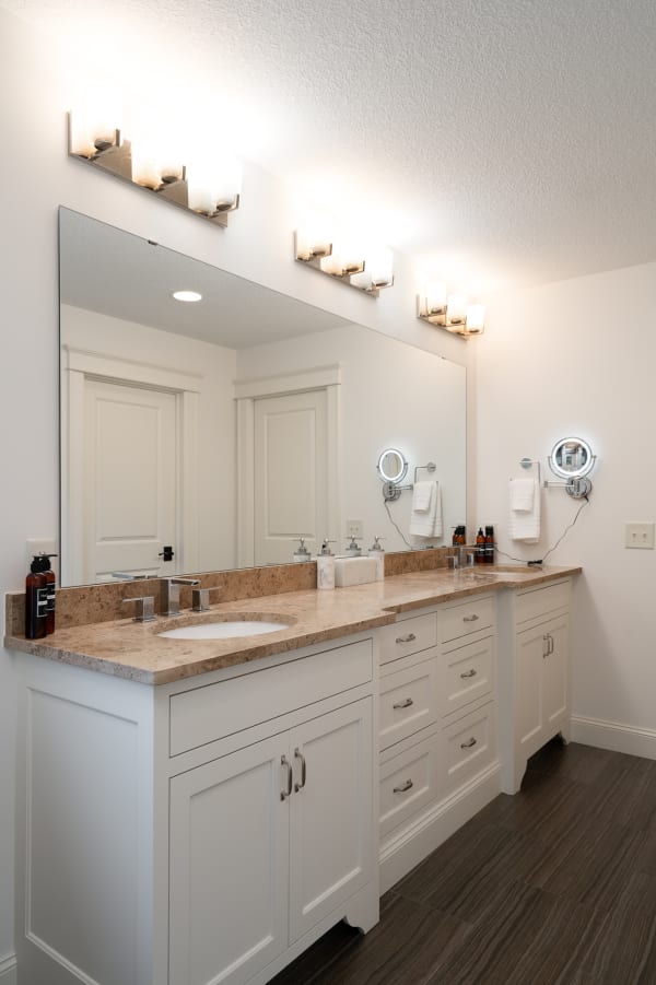 Modern bathroom vanity with dual sinks and illuminated mirror.