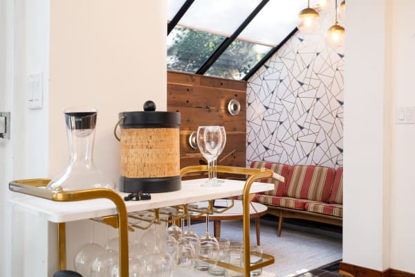 Modern living area with a bar cart and striped sofa.
