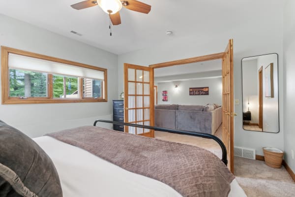 Interior of a cozy bedroom leading to a spacious living area with a sectional sofa.