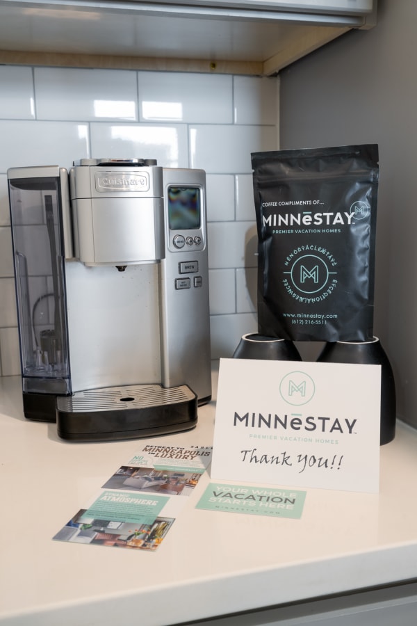 Modern kitchen countertop with Cuisinart coffee maker and MINNēSTAY coffee bag and cards.