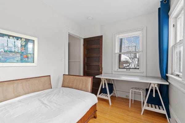 Cozy bedroom with a single bed, desk, and natural light.