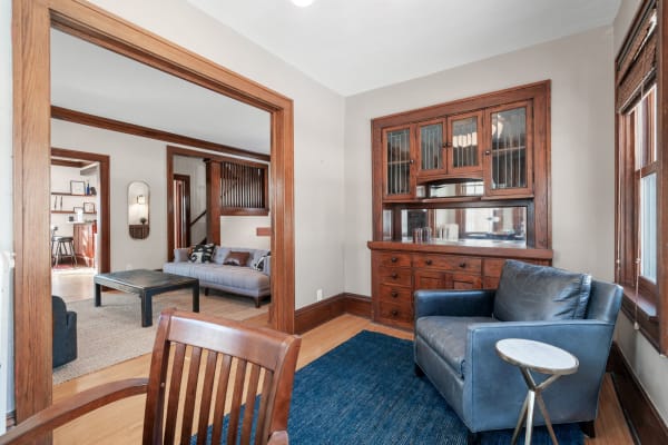 An inviting interior with a mix of blue and gray furniture, wooden cabinetry, and warm lighting.