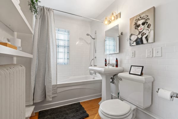 Modern bathroom with white subway tiles, a pedestal sink, and stylish décor.