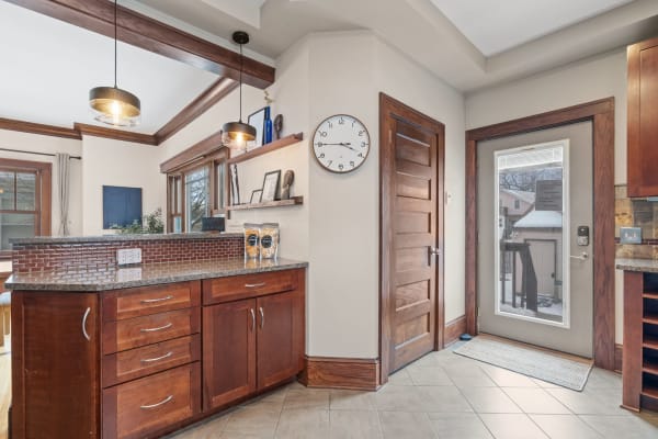 Cozy kitchen interior with granite countertop and wooden cabinets.