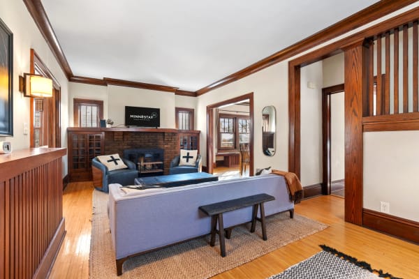 Living room with blue couch, brick fireplace, and wooden accents.
