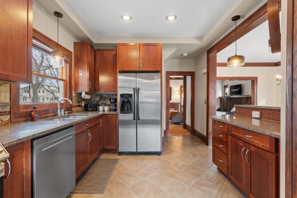 Modern kitchen with wooden cabinets and stainless steel refrigerator.