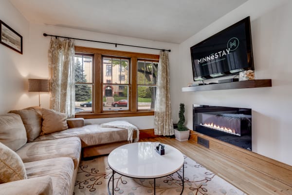 Inviting living room with sectional sofa, TV, and electric fireplace.