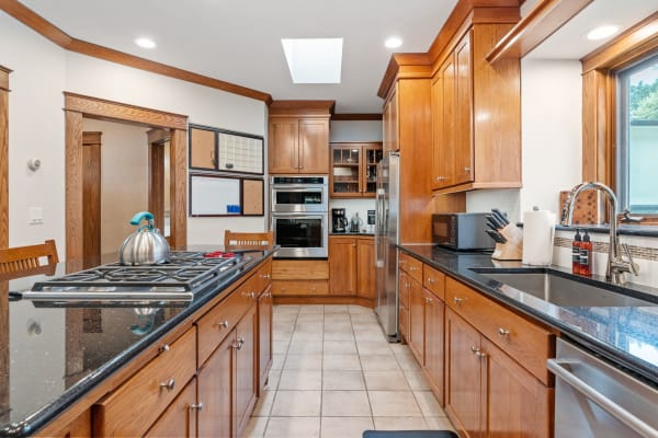 Spacious kitchen with wooden cabinets and black countertops