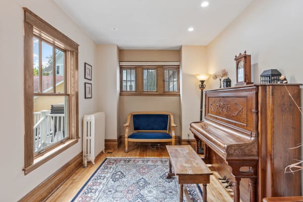 Interior view of a cozy room with a piano and wooden furniture.