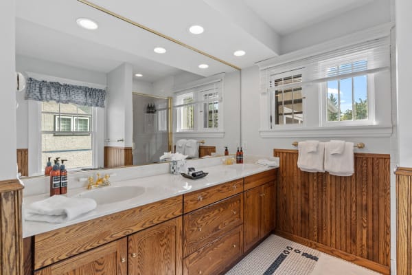 Bright and spacious bathroom with a marble countertop and wooden cabinets.