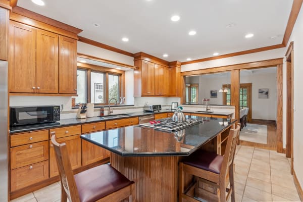 Modern kitchen with wooden cabinets and black granite island.
