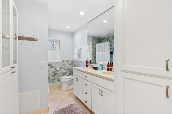 Modern bathroom with light blue walls, a double sink, and contemporary fixtures.