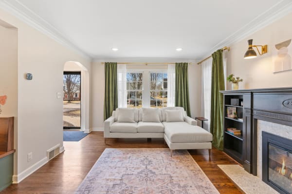 Cozy living room with a sectional sofa, bookshelf, and bright natural light.