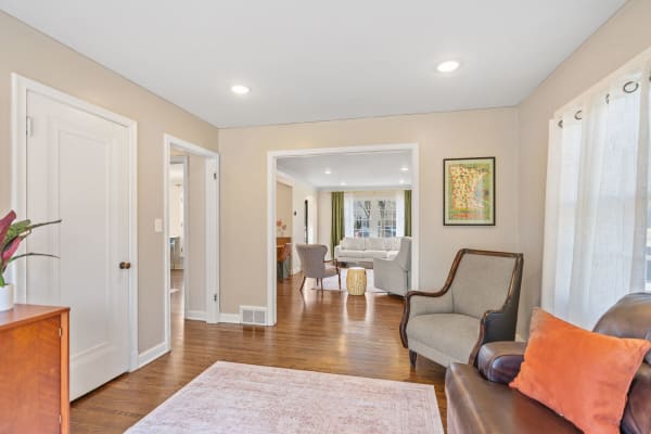 A bright living space with a leather sofa and a light gray couch, accentuated by natural light and an open layout.