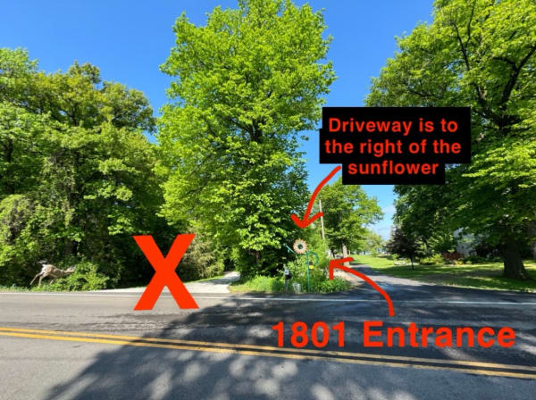 Intersection showing the entrance to property 1801 with a sunflower sign and a caution mark.