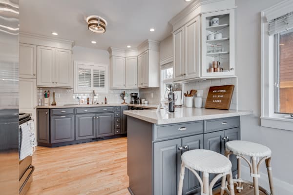 Stylish kitchen interior featuring two-tone cabinets and a cozy seating area.