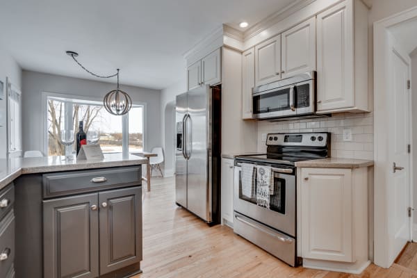 Modern kitchen with stainless steel appliances and bright windows.