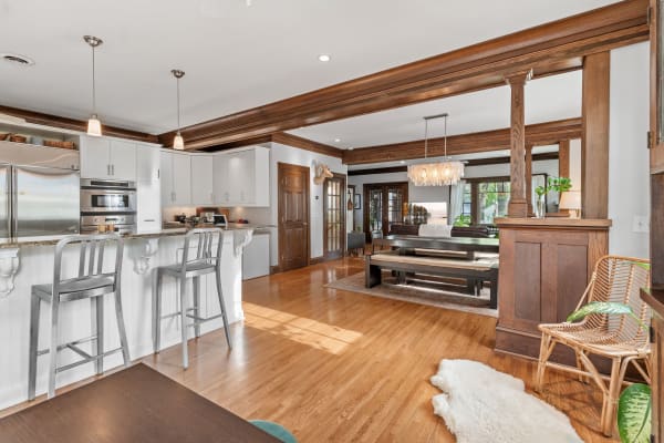 Open-concept kitchen and living room with white cabinetry and wooden accents.