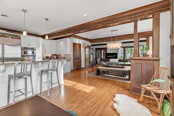 A bright and modern living area with kitchen, featuring rich wood accents and contemporary furnishings.
