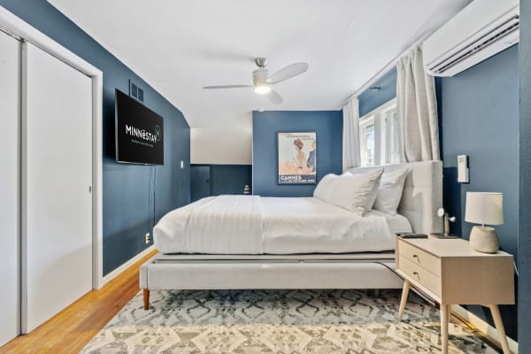 Cozy bedroom with blue walls, a gray bed, and modern furnishings.