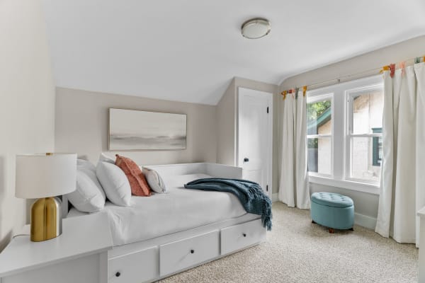Cozy bedroom with a daybed, decorative pillows, and natural light.