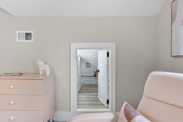 Interior view showing a dresser, a small white horse figurine, and a doorway leading to another room.