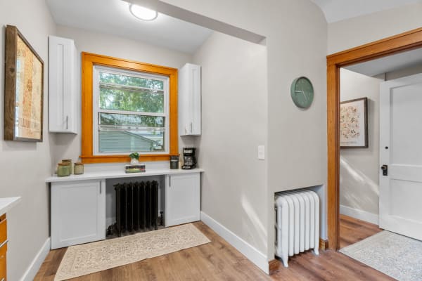 Cozy entryway featuring a window, white cabinetry, and natural wooden accents.