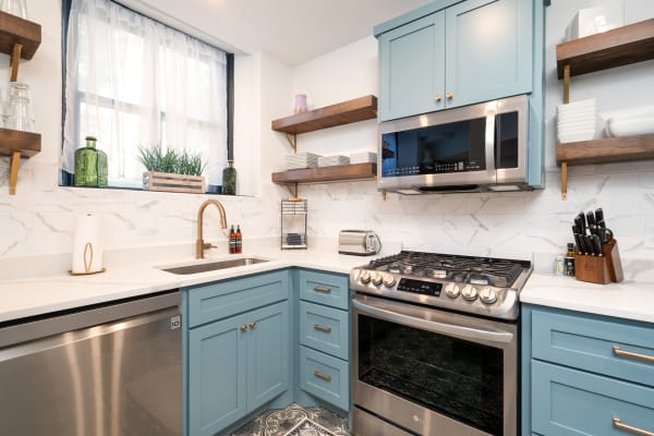 Cozy kitchen with blue cabinets, white countertops, and natural light.