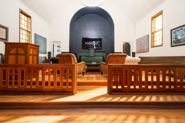 Interior of a room with high ceilings, sofas, and artistic wall decor.