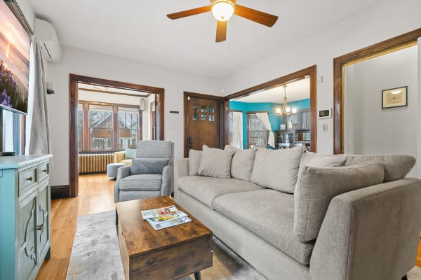 A modern living room featuring a gray sofa and a large window.