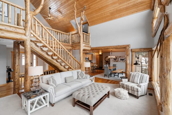 Interior view of a spacious living area featuring wooden accents, a staircase, and comfortable furniture.