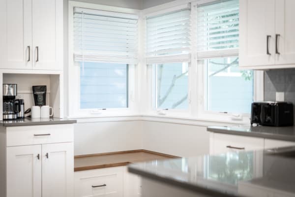 Modern kitchen with coffee machine, mugs, and natural light through the window.