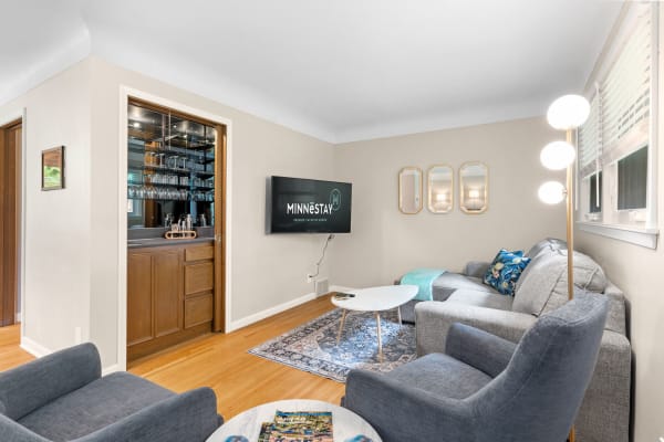 Cozy living room with a bar, gray sofa, and modern decor.