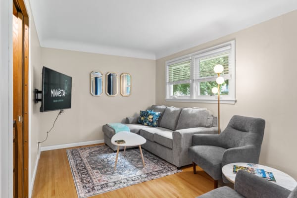 Cozy living room with gray sofa, TV, and decorative mirrors.