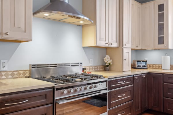 Contemporary kitchen with stainless steel appliances and a mix of dark and light wood cabinetry.