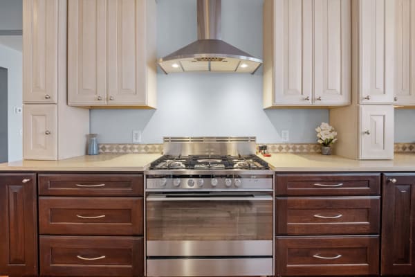 Modern kitchen with stainless steel stove and light wood cabinets.